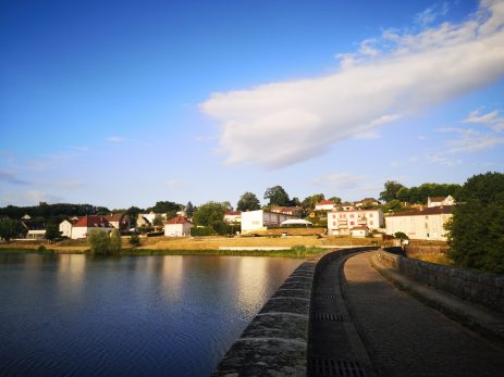 écologie, Vue du barrage de Saint-Sernin-du-Bois avec le village en arrière-plan sous un ciel bleu.