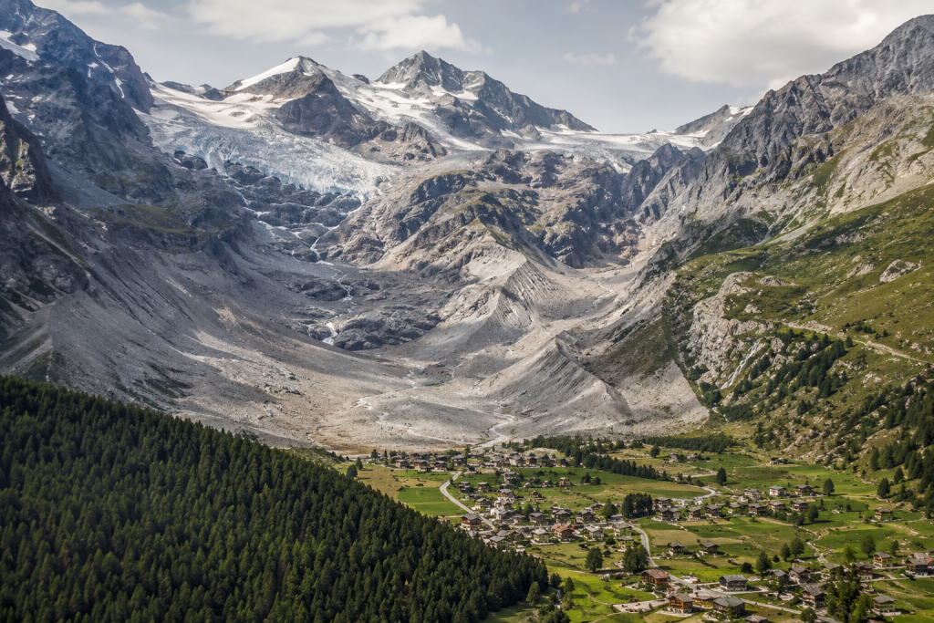 Glacier en recul dans les Alpes dominant une vallée européenne habitée